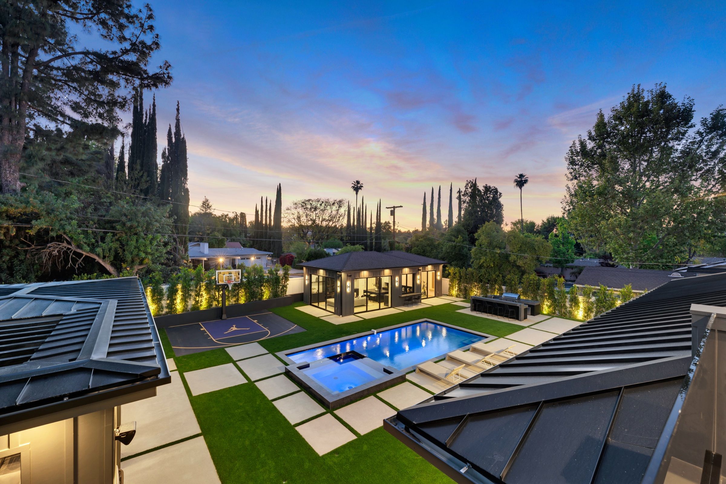 The pool, spa and lawn from the roofline at dusk