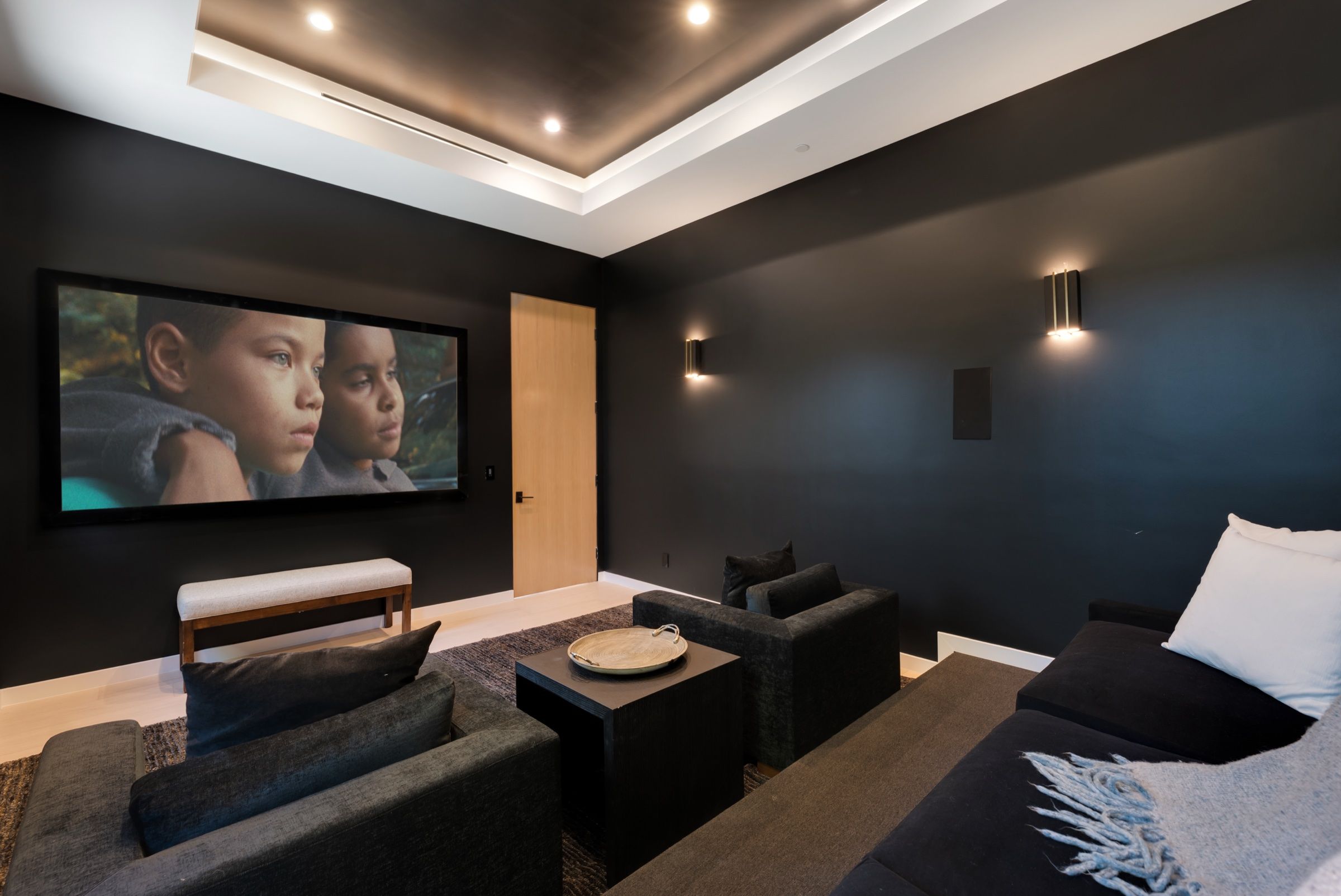 The home theater with a wide screen and lounge seating