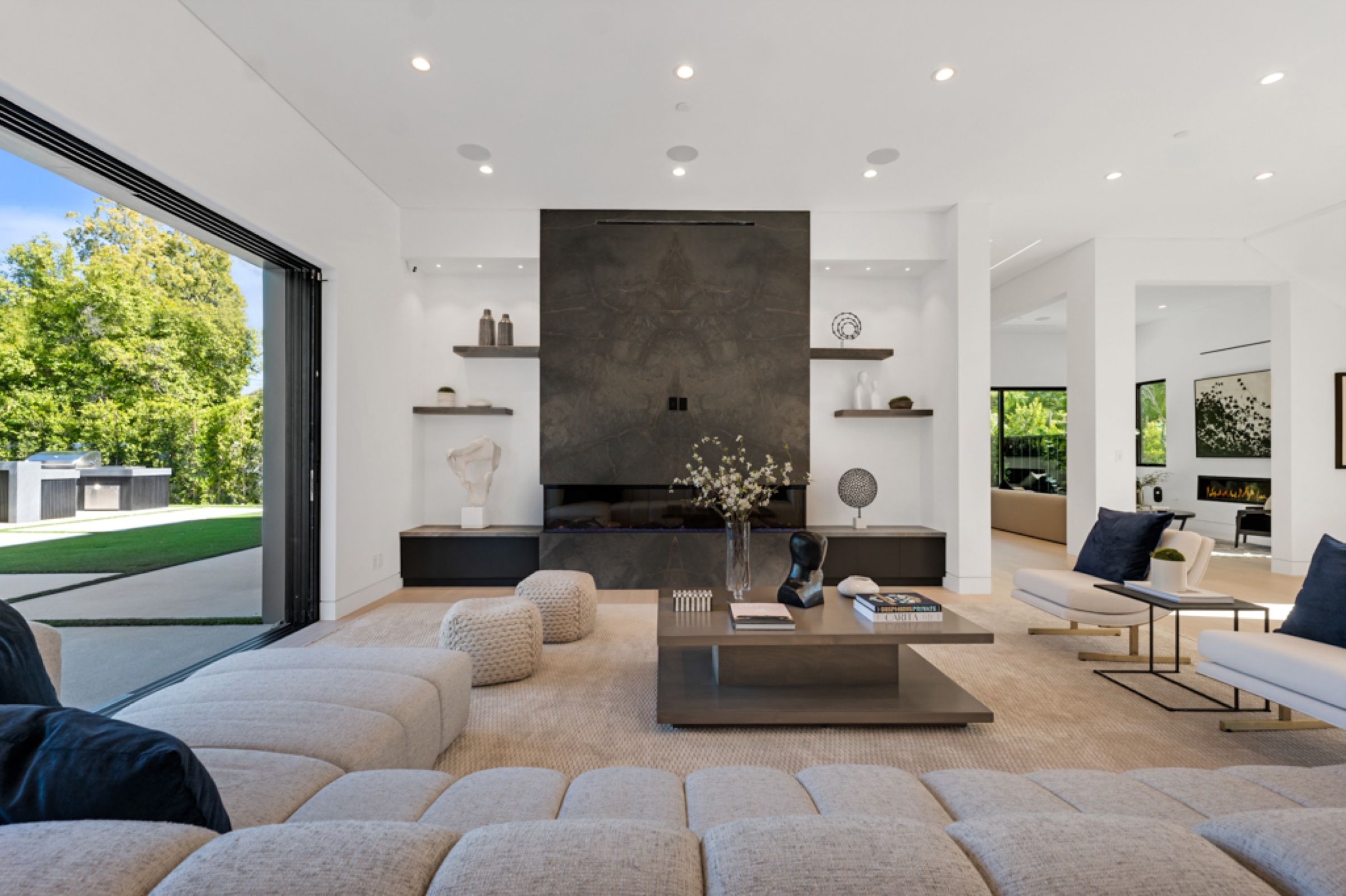 The great room with a long sofa and a stone fireplace wall