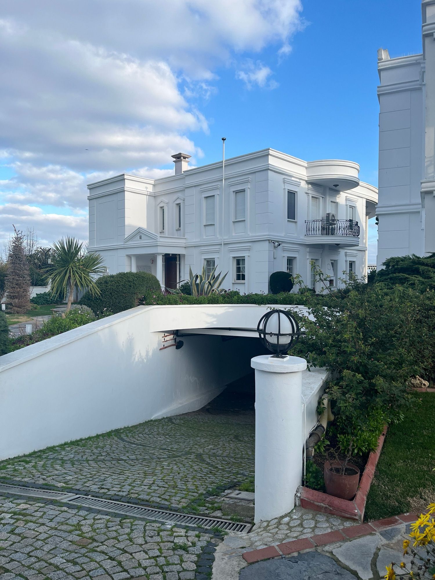 A white mansion among palms and clipped hedges
